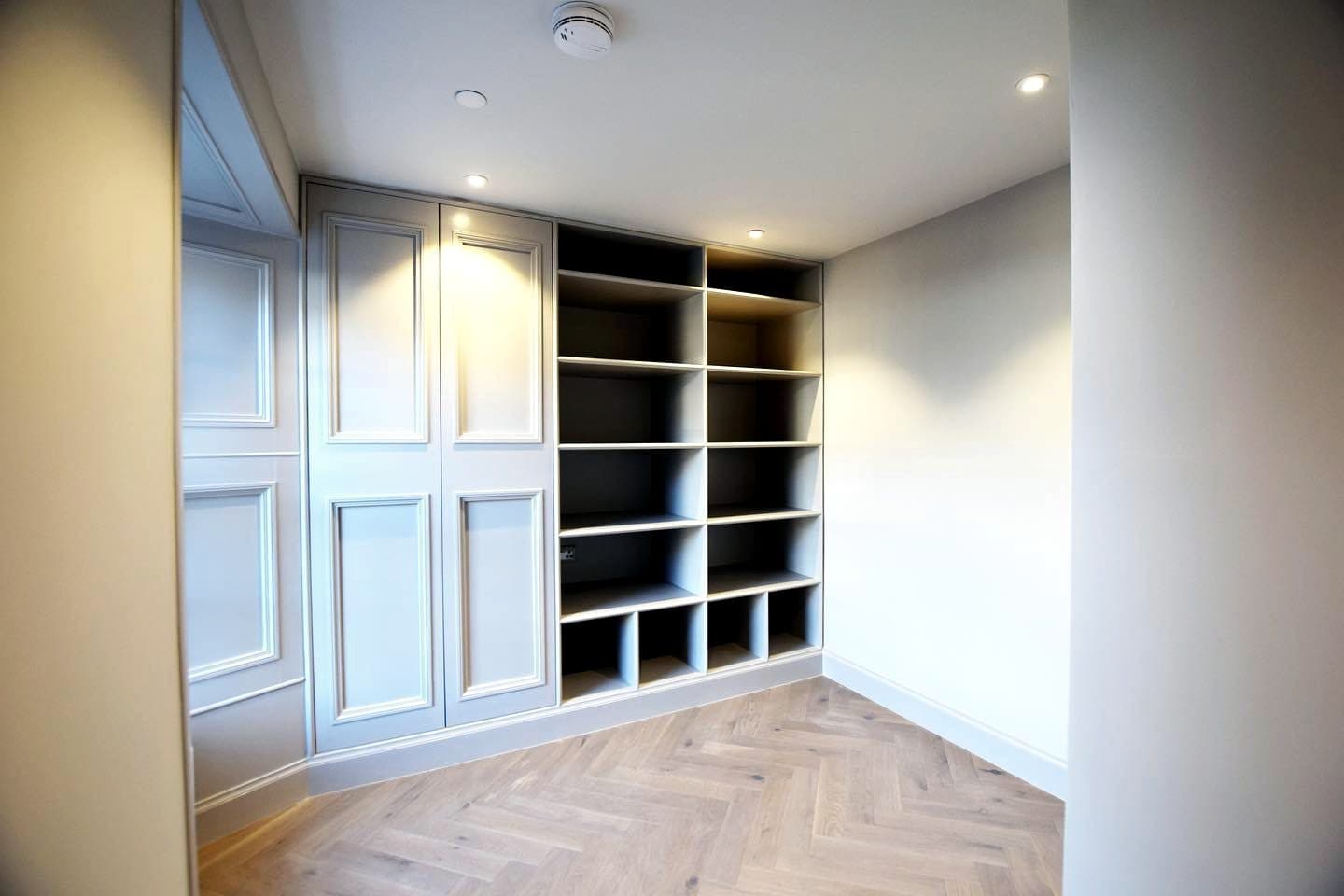 Bespoke fitted wardrobes and shelving over herringbone oak flooring