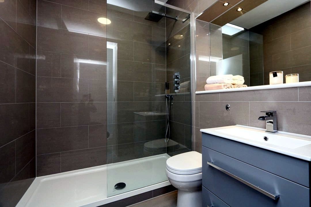 Grey tiled shower room with walk-in screen